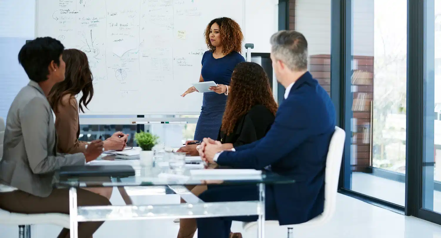 woman talking presentation with staff in office - finance report